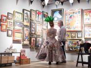 Man and woman look at art on wall at fair 2018