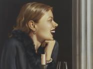 A woman sits at a bar, seemingly alone, laughing with a bandaged hand and a glass of wine