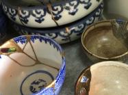 detail photo of a collection of pottery wares repaired via Kintsugi