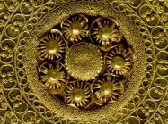 Detail shot of a gold ear-stud: disc decorated with granulation, filigree and beaded wire. 530BC-500BC