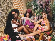 three women sit and look at viewer 