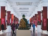 interior of a museum with large buddha and other displays, people milling about