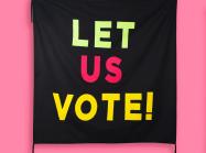 black banner that reads "let us vote" hanging on a pink banner