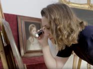expert examines painting with flashlight