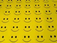 a sheet of yellow fabric with rows and rows of smiley faces