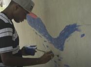 You man paints wall at playground
