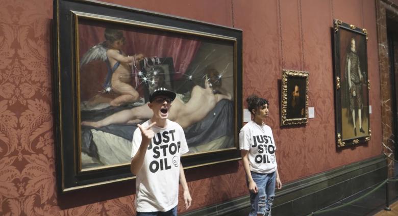 Just Stop Oil activists standing by the Rokeby Venus after hitting the protective glass with safety hammers.