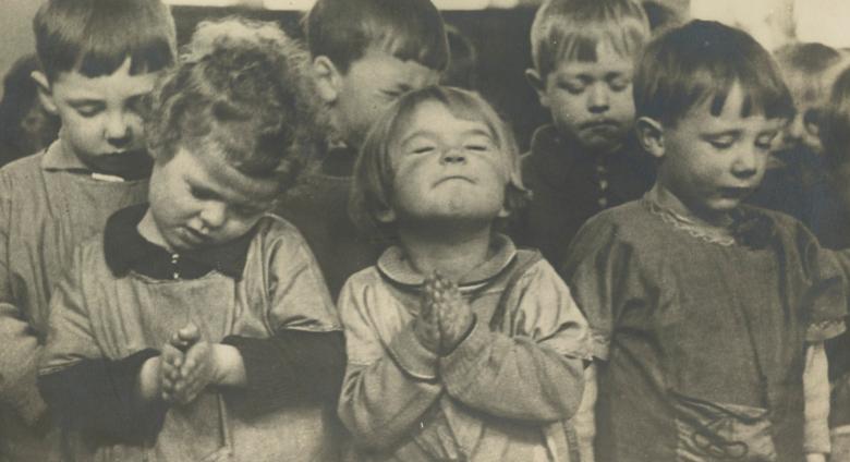 group of small children close their eyes in prayer