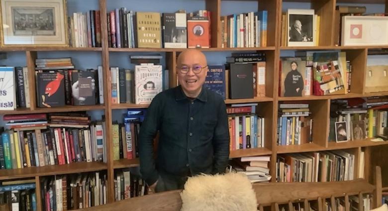 Phong Bui in front of his many bookshelves.