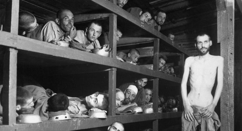 These are slave laborers in the Buchenwald concentration camp near Weimar; many had died from malnutrition when U.S. troops of the 80th Division entered the camp. The very ill man lying at the back on the lower bunk is Max Hamburger, who had TBC and severe malnutrition. He recovered and became a psychiatrist in the Netherlands. Second row, seventh from left is Elie Wiesel. Photograph taken 5 days after rescue.