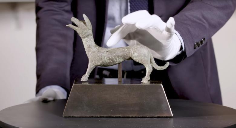 Hand touching bronze dog statue