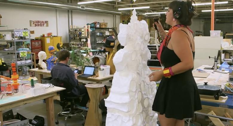 artist works on sculpture in studio
