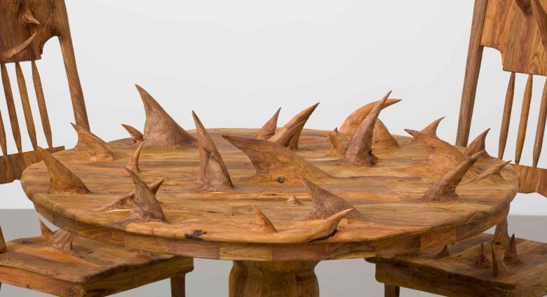 a circular wooden table and chairs, all covered in large thorny protrusions