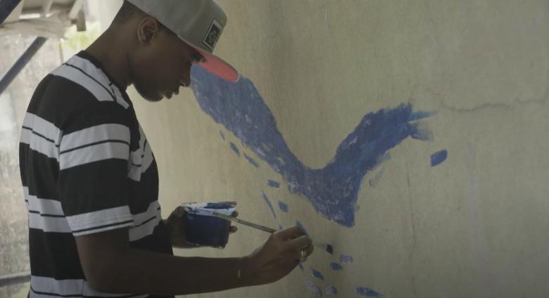 You man paints wall at playground