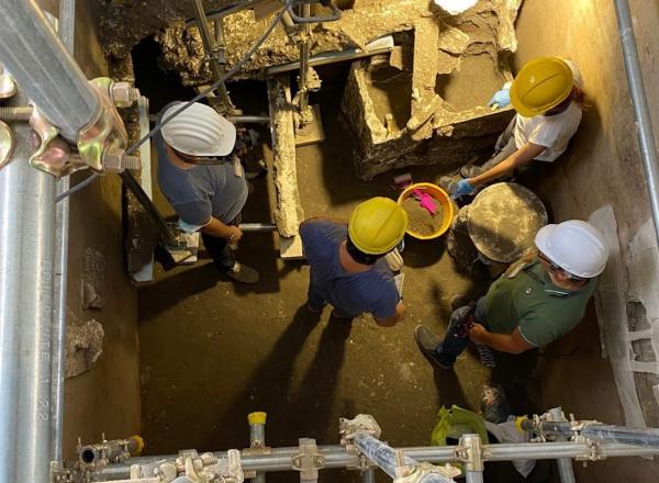 Archaeologists at the Pompeii Archaeological Park stand within the first-floor bedroom in the house of the lararium. Credit: Archaeological Park of Pompeii.