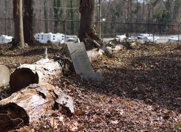 The backmost section of Geer cemetery is hedged in by a parking lot for a telephone company. Fallen trees are a common disruption in this portion of the cemetery and pose threats to the preservation of headstones.