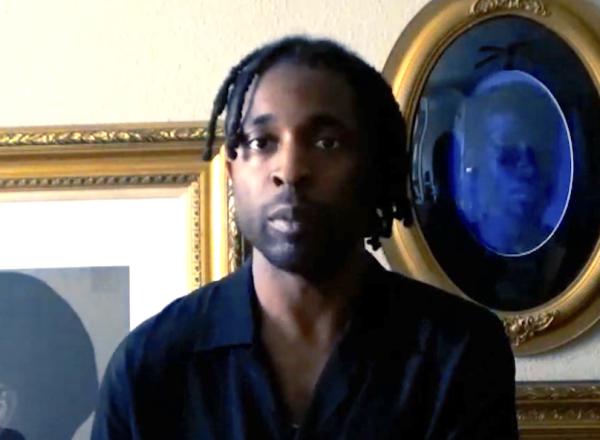 image of Fagan in front of pictures looking at camera