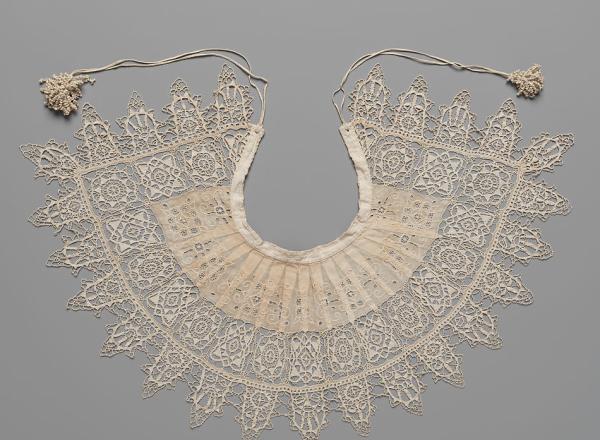 Detailed and petite lace collar. Unknown, 1610-1620, Standing Band (Collar) with Tassels, Cutwork, needle lace, reticello, punto in aria, embroidery, linen. Gift of Mrs. Edward S. Harkness, 1930. The Metropolitan Museum of Art. .