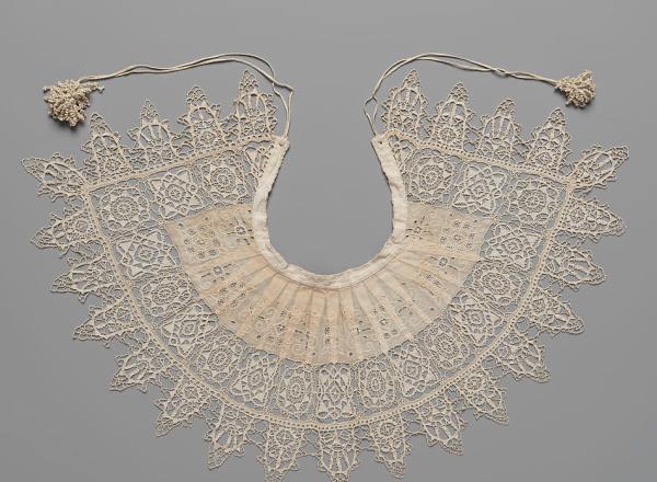 Detailed and petite lace collar. Unknown, 1610-1620, Standing Band (Collar) with Tassels, Cutwork, needle lace, reticello, punto in aria, embroidery, linen. Gift of Mrs. Edward S. Harkness, 1930. The Metropolitan Museum of Art. .
