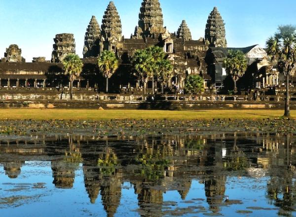 Angkor Wat temple makes up skyline beyond body of water 