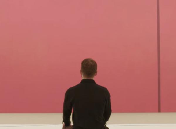 man sitting in front of pink canvas