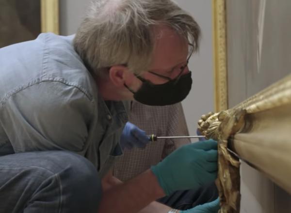 men working on art in masks