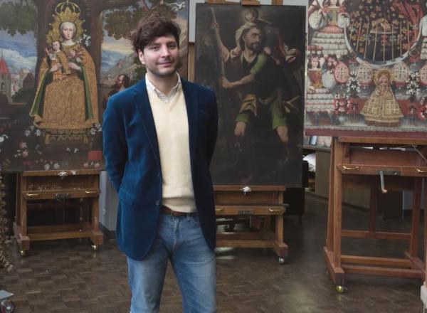 José Luis Lazarte Luna, Assistant Conservator in Paintings Conservation, who was born and raised in Lima, Peru, stands in front of several paintings in the Cuzco School style that were recently gifted to The Met 