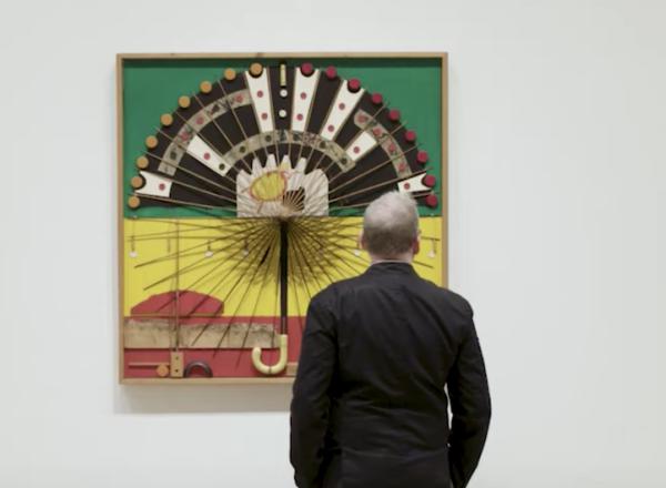 curator looking at noah purifoy work