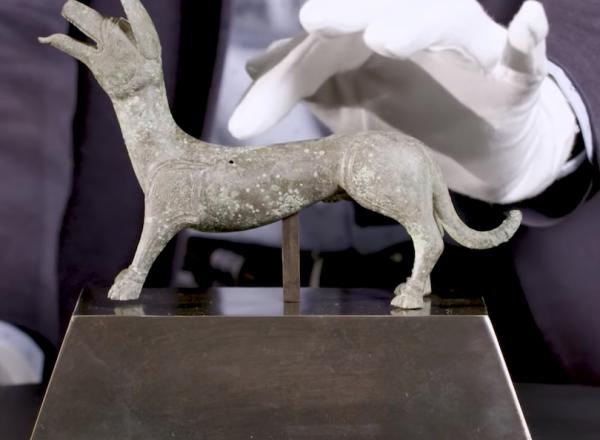 Hand touching bronze dog statue