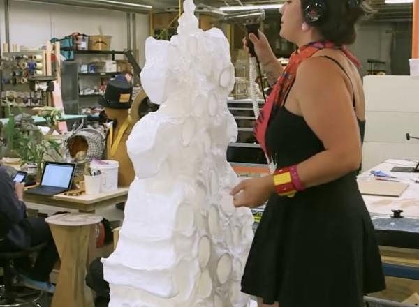 artist works on sculpture in studio