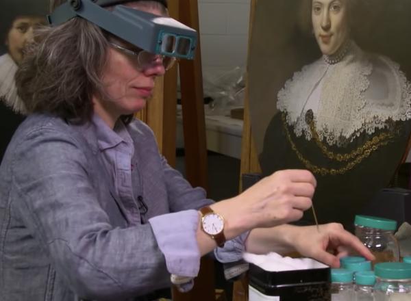 Conservator at work on painting