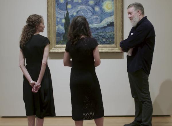 group looks at Starry Night on wall in gallery