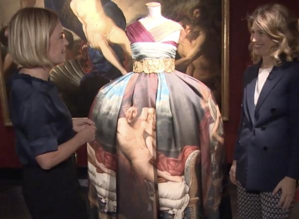 Examining dress with painting in background