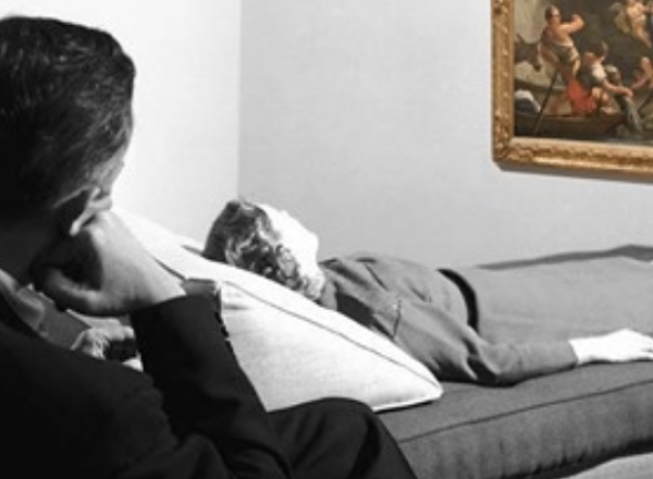 woman on therapist couch looks at painting on wall