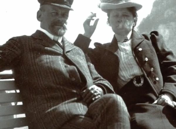 Photograph of Wilhelm and Henny Hansen smoking in front of water 