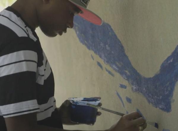 You man paints wall at playground