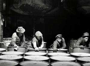 "Workmen stacking drums of grease ready for shipment.", March 1944