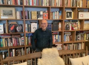Phong Bui in front of his many bookshelves. 
