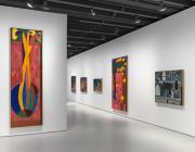 installation view, brightly colored tall paintings in a gallery with white walls