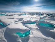 a snowy landscape with bit of brilliant blue ice