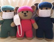 three crocheted teddy bears in scrubs and face masks