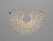Detailed and petite lace collar. Unknown, 1610-1620, Standing Band (Collar) with Tassels, Cutwork, needle lace, reticello, punto in aria, embroidery, linen. Gift of Mrs. Edward S. Harkness, 1930. The Metropolitan Museum of Art. .