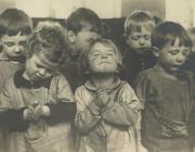group of small children close their eyes in prayer