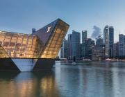 Illuminated polyhedral building Louis Vuitton over the water at Marina Bay in the evening, with skyscrapers of the Central Business District in the background, Singapore. License