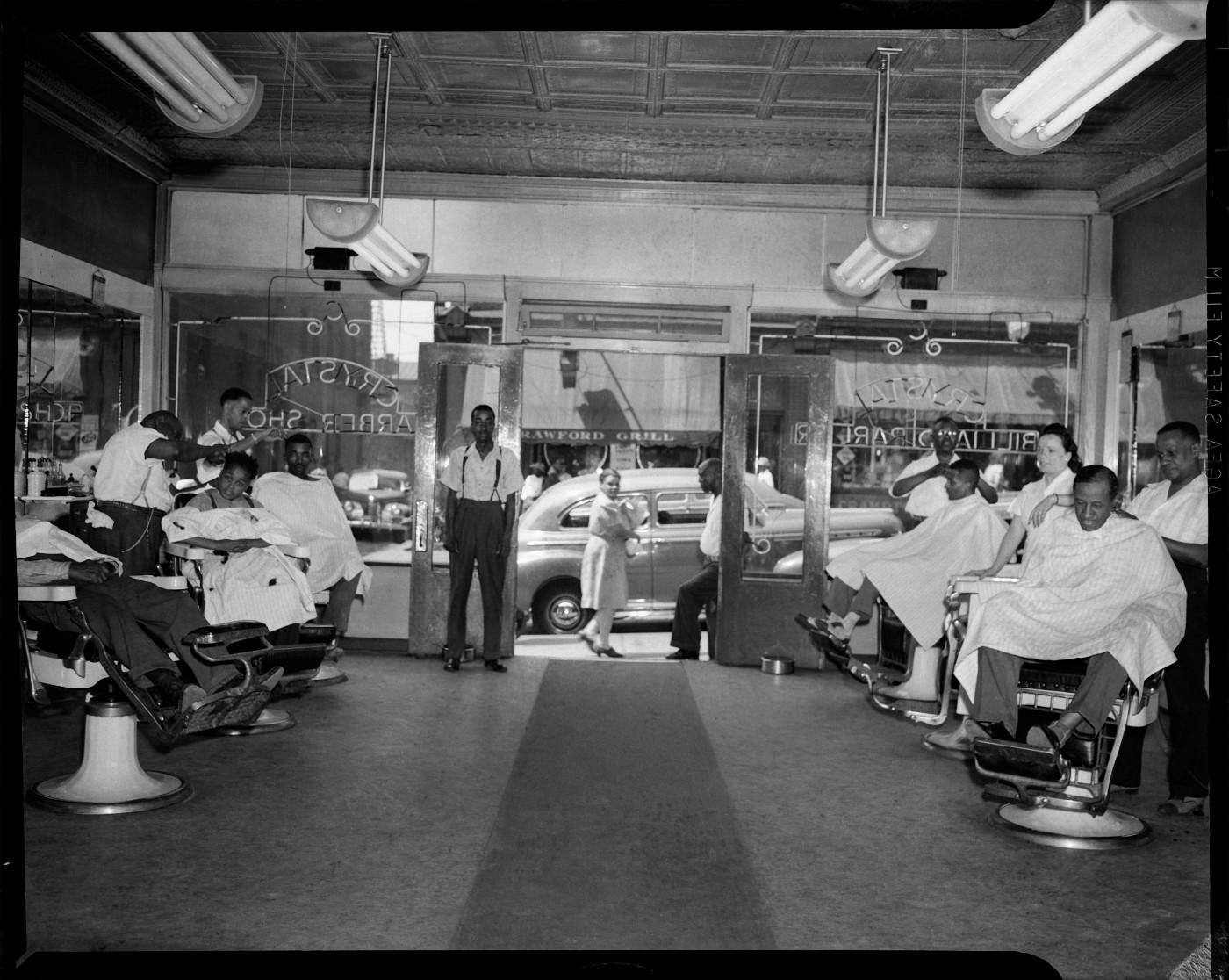 Charles “Teenie” Harris, ‘Barbers at work in the Crystal Barber Shop with view of Crawford Grill No. 1 through front door,’ c. 1949