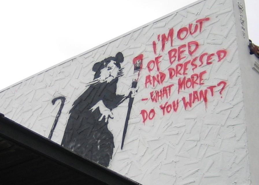 banksy rat mural in los angleles with text "I'm out of bed and dressed -- what more do you want?"