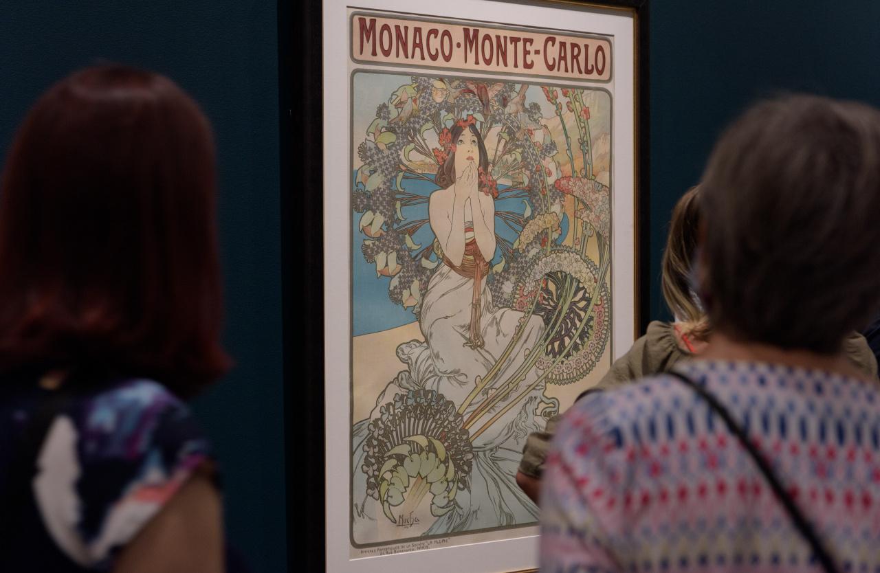 Installation view of Alphonse Mucha: Art Nouveau Visionary featuring Mucha's Monaco – Monte Carlo (1897).
