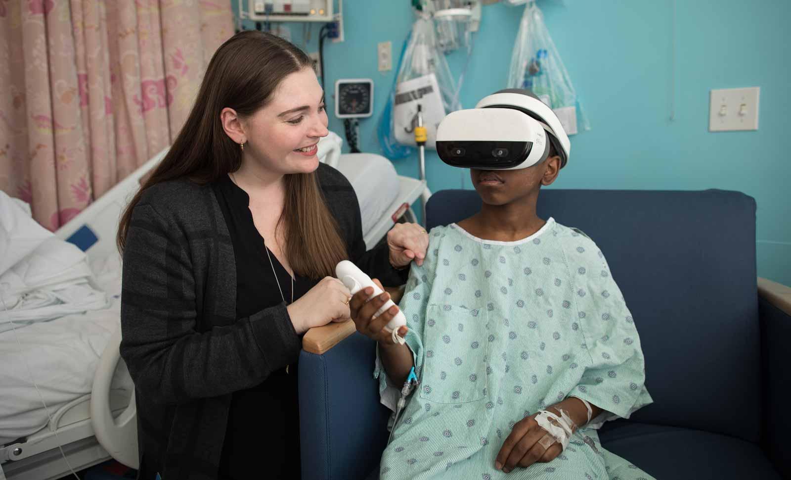 Montefiore Health System art curator Olivia Davis assists with a patient with a VR experience.