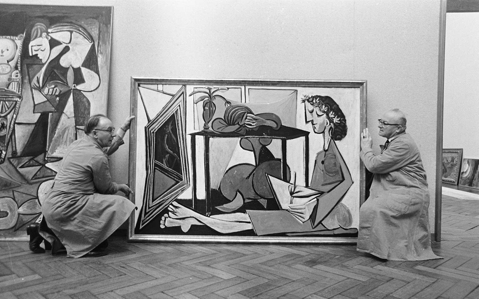 Men setting up Picasso paintings in the Stedelijk Museum, 1967; Jack de Nijs / Anefo, CC0, via Wikimedia Commons