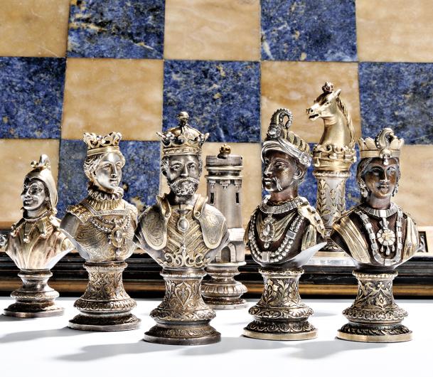 silver chess set in front of blue and white chess board